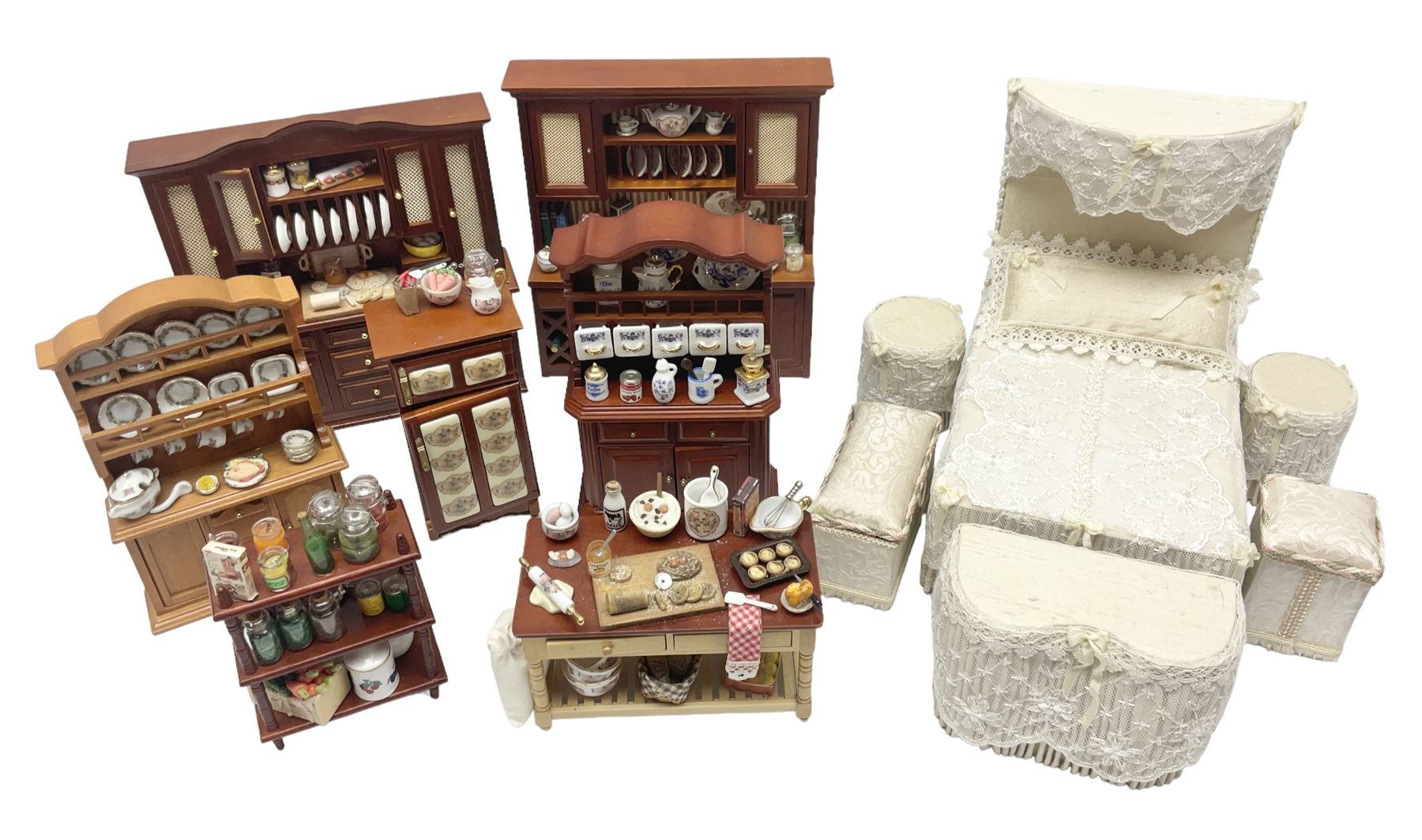 Collection of kitchen and bedroom dolls house furniture, to include two units housing Reutter, Germany ceramic plates, tea wares and accessors comprising one example with a Belfast sink with various pots and pans and jars, the second housing various baking equipment, two dressers, baking table, shelf unit housing various jars of herbs and basket of produce, fridge, and lace and jacquard bedroom suite including bed, pair of bedside tables, dressing table and ottoman