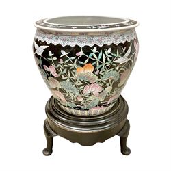 Large 20th century Chinese famille noir glazed porcelain jardinière, of ovoid form, the exterior enamelled with butterflies and white cranes amidst blossoming water lilies and pads against a black ground, between two stylised polychrome borders and beneath a key border to rim, the interior enamelled with red koi fish swimming amongst water fronds and weeds, with printed red character mark beneath, the whole upon an ebonised hardwood stand with three cabriole legs, jardinière H42cm D47cm, including stand overall H69.5cm