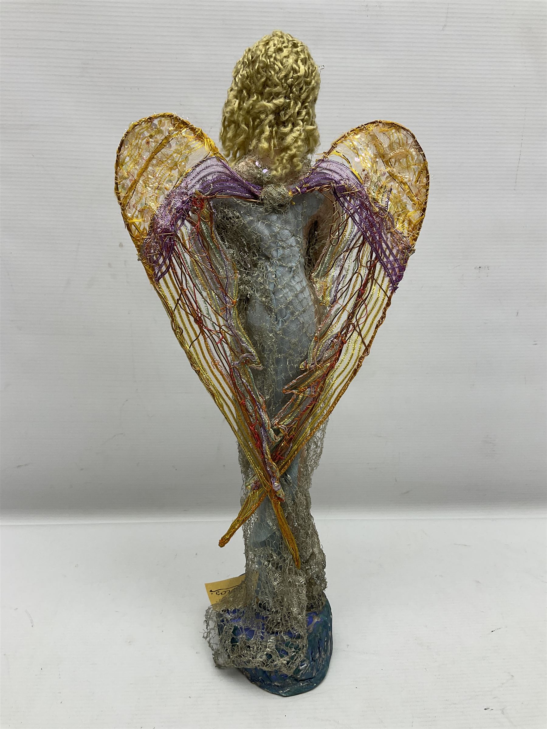 Anna Meszaros Hungary - hand made needlework figurine of an Angel with metallic lace full length dress and open threadwork wings; on moulded base H45cm Auctioneer's Note: Anna Meszaros came to England from her native Hungary in 1959 to marry an English businessman she met while demonstrating her art at the 1958 Brussels Exhibition. Shortly before she left for England she was awarded the title of Folk Artist Master by the Hungarian Government. Anna was a gifted painter of mainly portraits and sculptress before starting to make her figurines which are completely hand made and unique, each with a character and expression of its own. The hands, feet and face are sculptured by layering the material and pulling the features into place with needle and thread. She died in Hull in 1998.