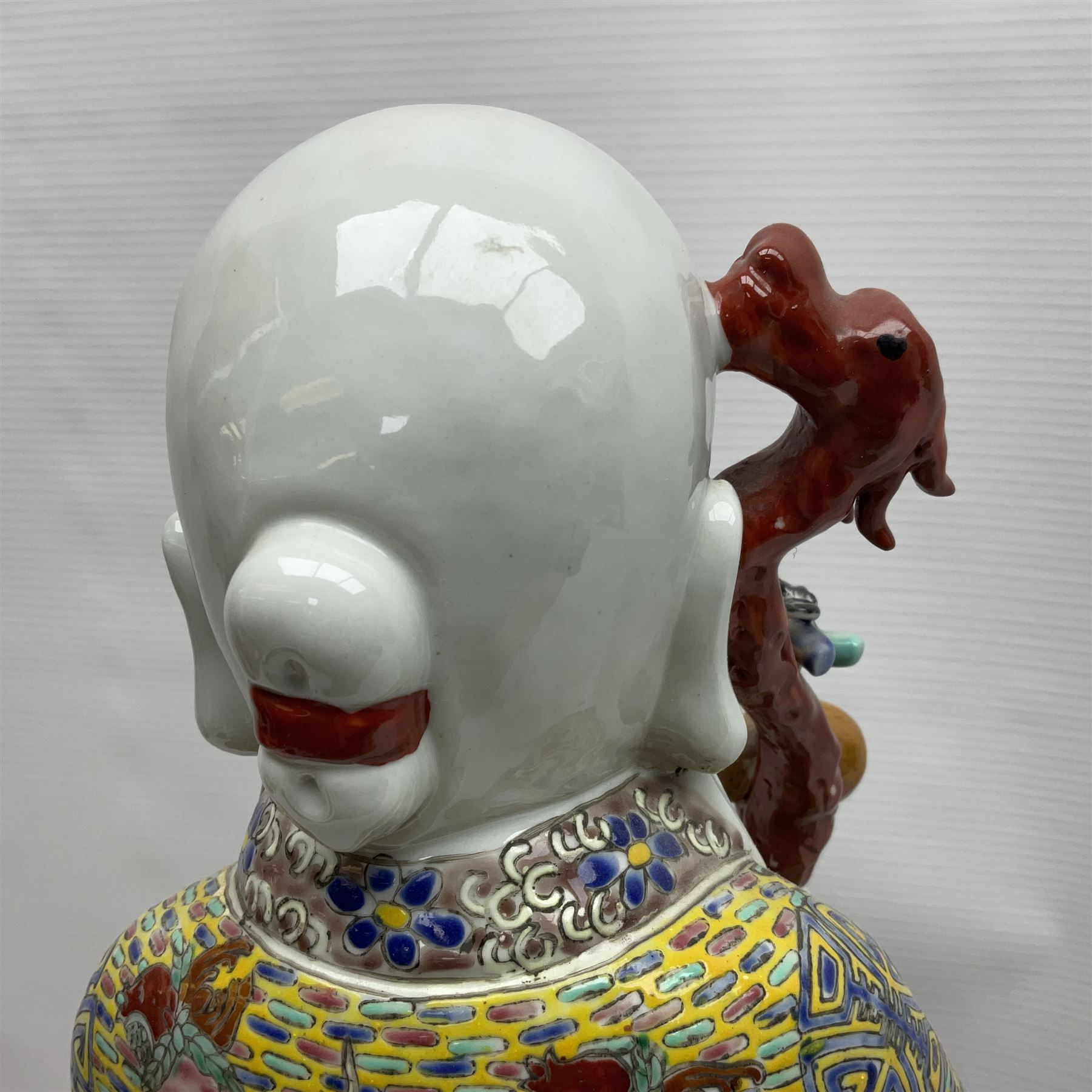 Chinese Republic Period porcelain figure, modelled as Shoulao, wearing elaborately enamelled robes decorated with peaches and flower heads, with impressed mark beneath, H55cm