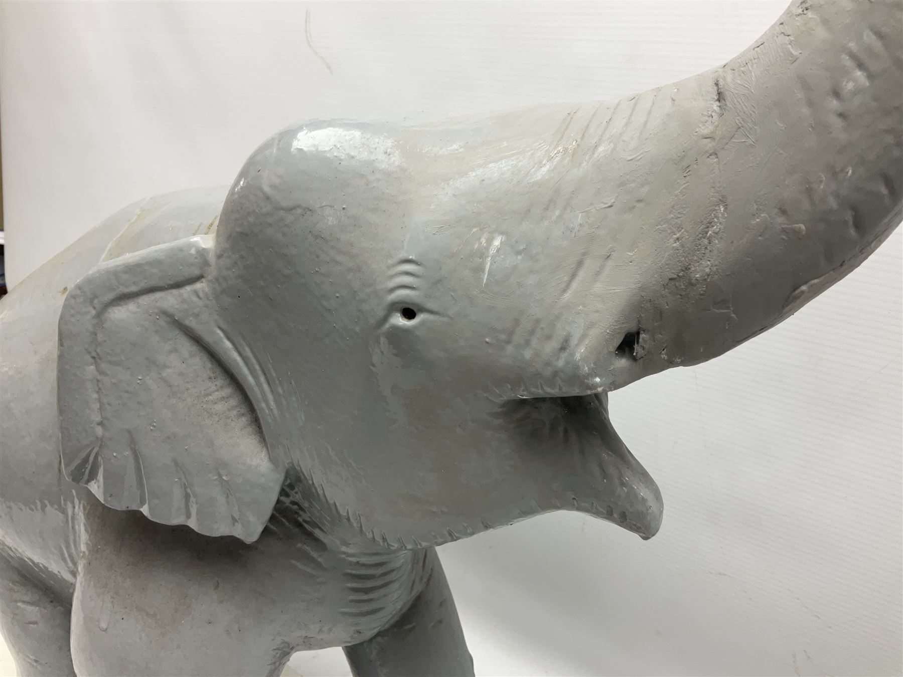 Composite figure of an elephant, painted grey, upon white base, L45cm H65cm