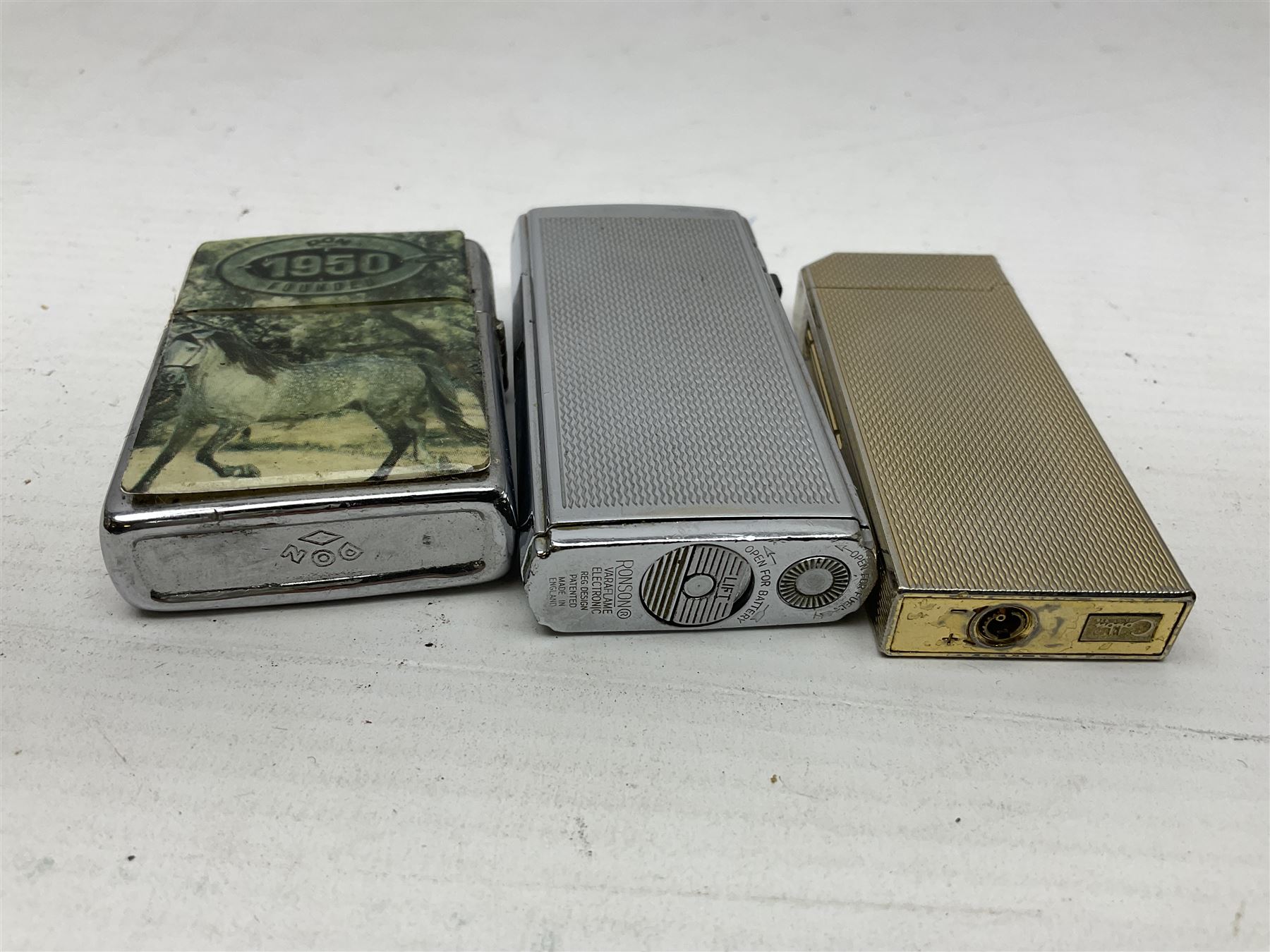 Collection of lighters, including Ronson Varaflame, Zorr Classic, Dunhill bark effect roller gas lighter, and faceted blue glass table lighter, etc