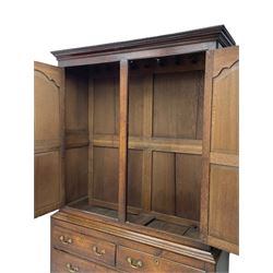 George III oak livery cupboard, projecting moulded cornice over two panelled doors, the upper panels within stepped ogee and arched moulded frame, the interior fitted with a single row of wooden hooks, two short and one long drawers, on bracket and return skirted base 