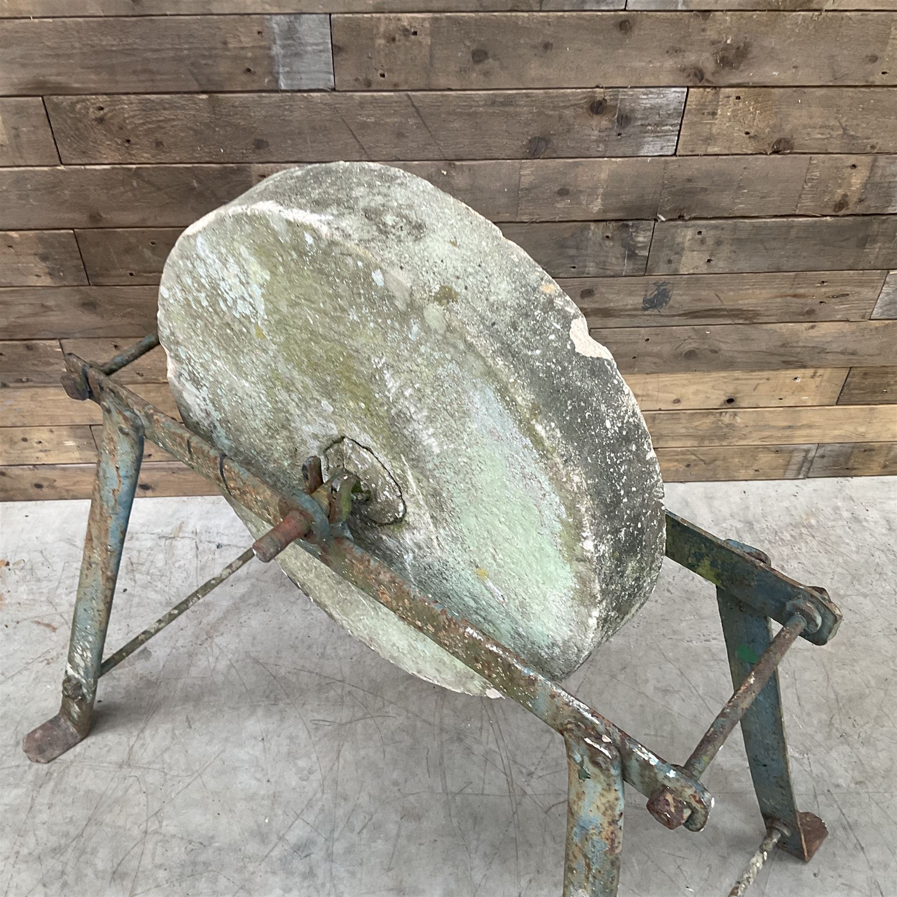 Vintage grindstone sharpening wheel mounted on metal stand, and a cast iron water pump