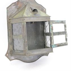 Early 20th century Arts and Crafts metal wall light or lantern, the projecting centre with three glass panels, the central panel opening on hinges, surmounted by a pointed top, upon a shaped back panel, overall H38.5cm D11cm W28cm 
