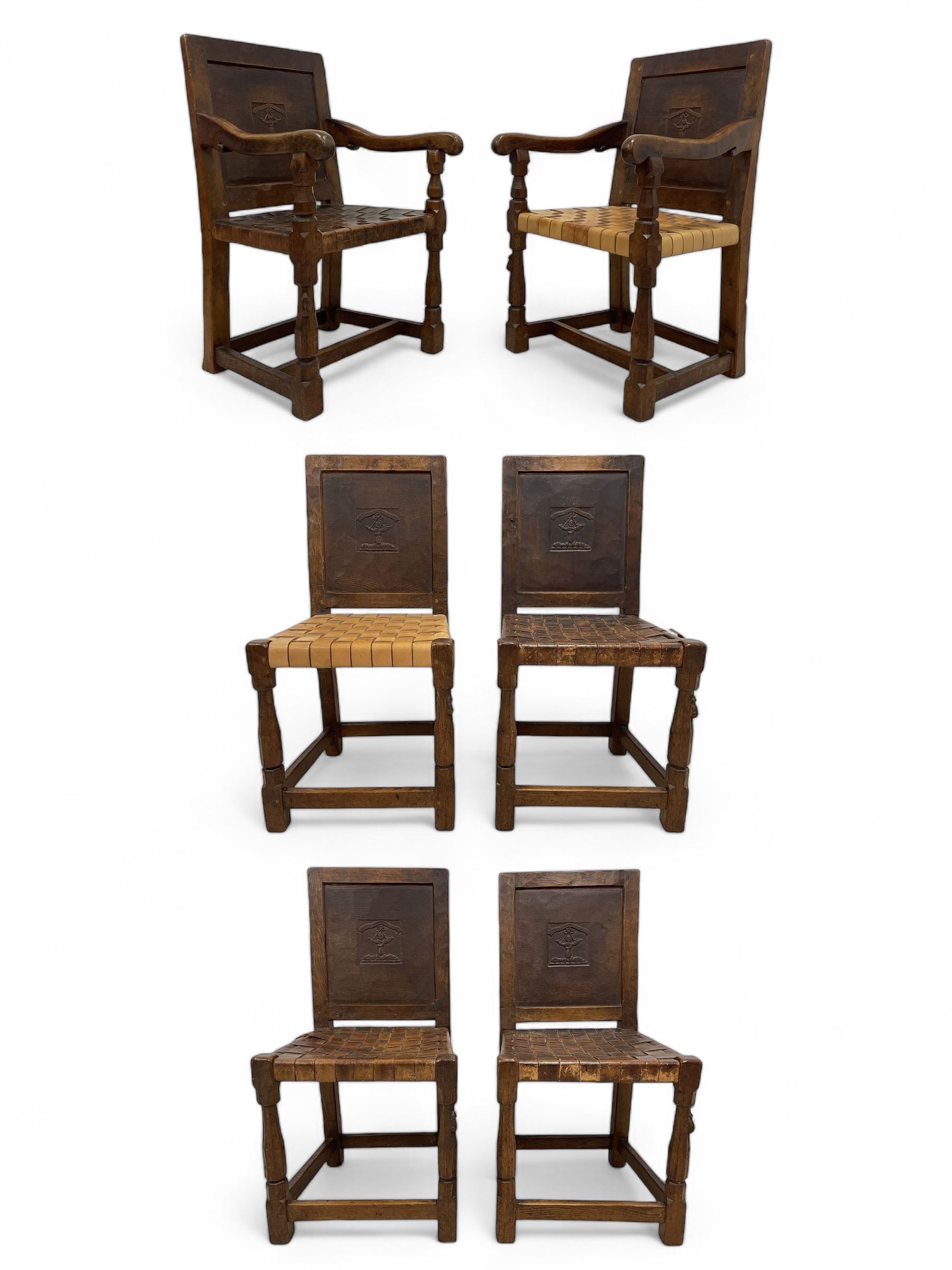 Mouseman - circa. 1930s set of six (4+2) oak dining chairs, panelled back carved with the Bagshawe family crest, the moto 'Forma Flos Fama Flatus' over an arm grasping a bugle-horn with ribbon tie and Yorkshire rose motif, adzed frame, leather lattice strap seat, on octagonal supports united by stretchers, two carvers and four side chairs, each carved with mouse signature, by Robert Thompson of Kilburn 

Provenance: Owned since manufacture by the Bagshawe family, descendants of the Staithes Group Artist Joseph Richard Bagshawe RBA (1870-1909).