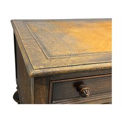 Early 20th century Jacobean design oak desk, with rectangular top inset with worn tooled leather, two frieze drawers over pedestals each fitted with a pair of panelled drawers, turned handles, on carved and fluted tapering legs united by stretchers 