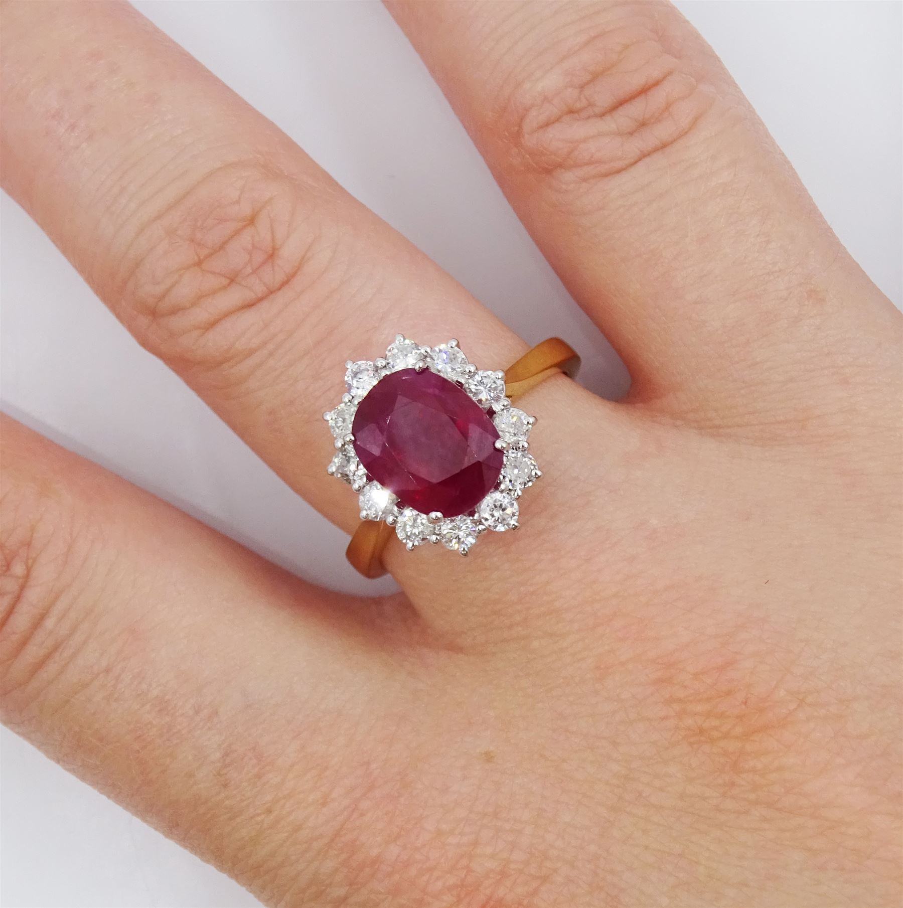 18ct gold oval cut ruby and round brilliant cut diamond cluster ring, hallmarked, ruby approx 3.40 carat, total diamond weight approx 0.65 carat