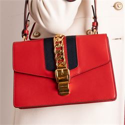 Gucci - ‘Sylvie’ Small Shoulder Bag, introduced circa 2016 under Alessandro Michele, in red calfskin leather with signature web stripe, gold-tone chain and buckle fastening and hardware, flat leather shoulder strap with alternative web-stripe grosgrain strap, unused with original dust bag