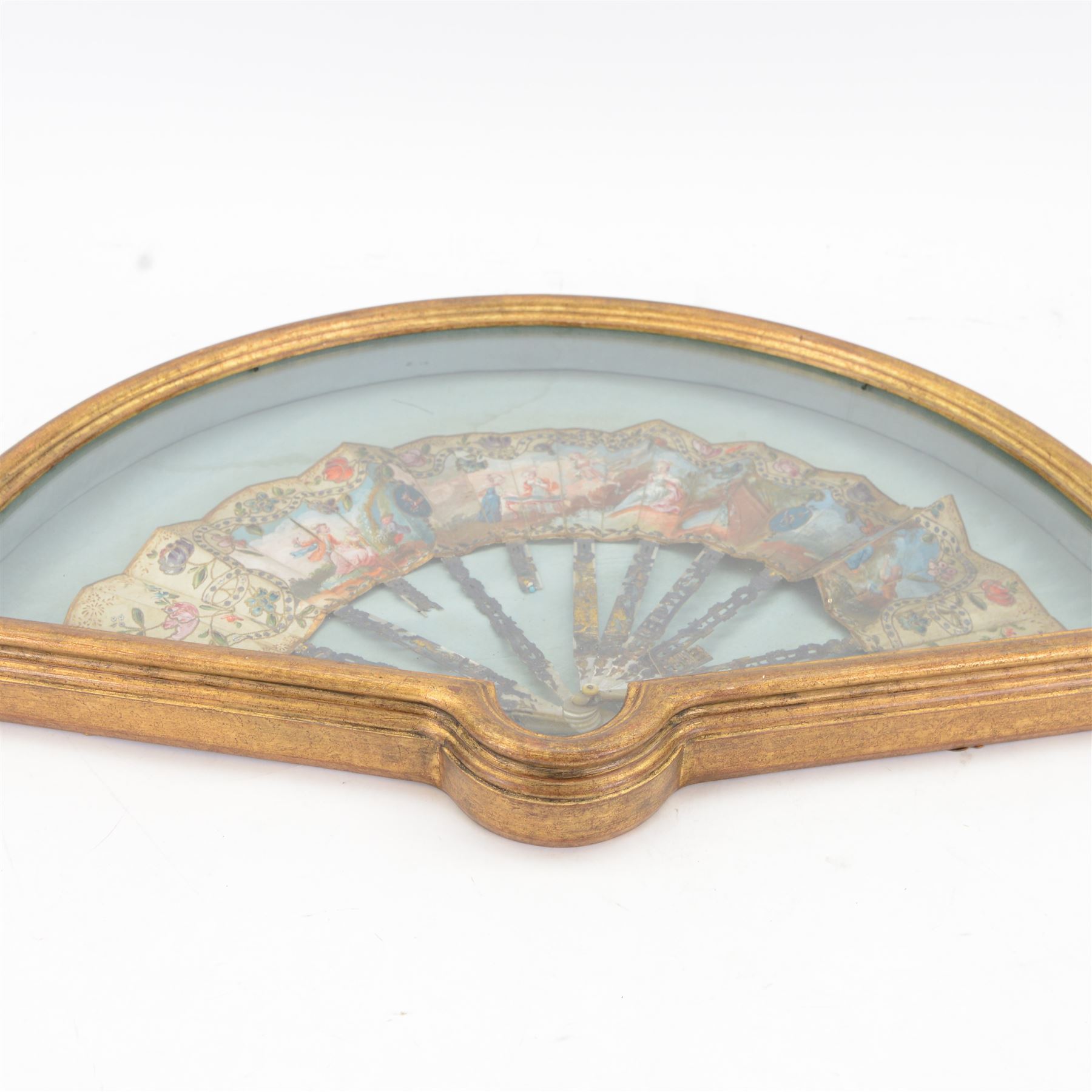 18th century fan, possibly Italian, the mother-of-pearl sticks and guard carved, pierced, silvered and gilded, the silk leaf painted with figures at various pursuits in gardens after Fragonard, within a border of brightly painted flowers, silvered sequins and gilt foliage, framed and glazed, overall H37cm L60cm

Provenance: From the Estate of the late Dowager Lady St Oswald