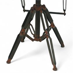 Pair of 20th century brutalist industrial metal swivel bar stools, sheet seats with strap backrests with bolted design to the sides, raised on quadripod bases with angular strut supports, the seats height-adjustable and swivelling