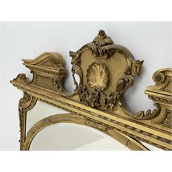 19th century gilt wood and gesso overmantel mirror, the shaped swan neck pediment with floral swag and shell decoration, oval central bevelled mirror plate with a reed and leaf moulded surround, segmented corner bevelled panels, shaped corner brackets with acanthus scroll decoration, small central shelf with gadrooned underside, on stepped gilt and ebonised moulded base