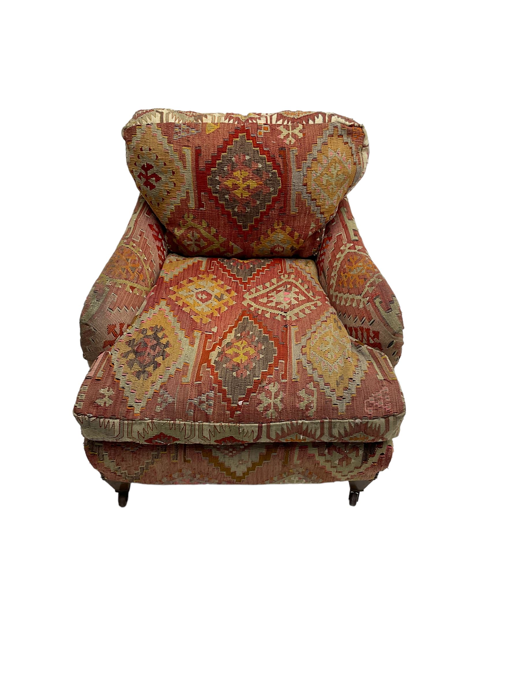 Early 20th century Howard style armchair, upholstered in Kilim fabric with sprung seat, hardwood frame, square tapering supports with brass and ceramic castors