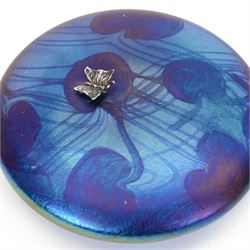 John Ditchfield for Glasform disc paperweight in iridescent blue with purple lily trail and silver hallmarked butterfly to top, D12cm