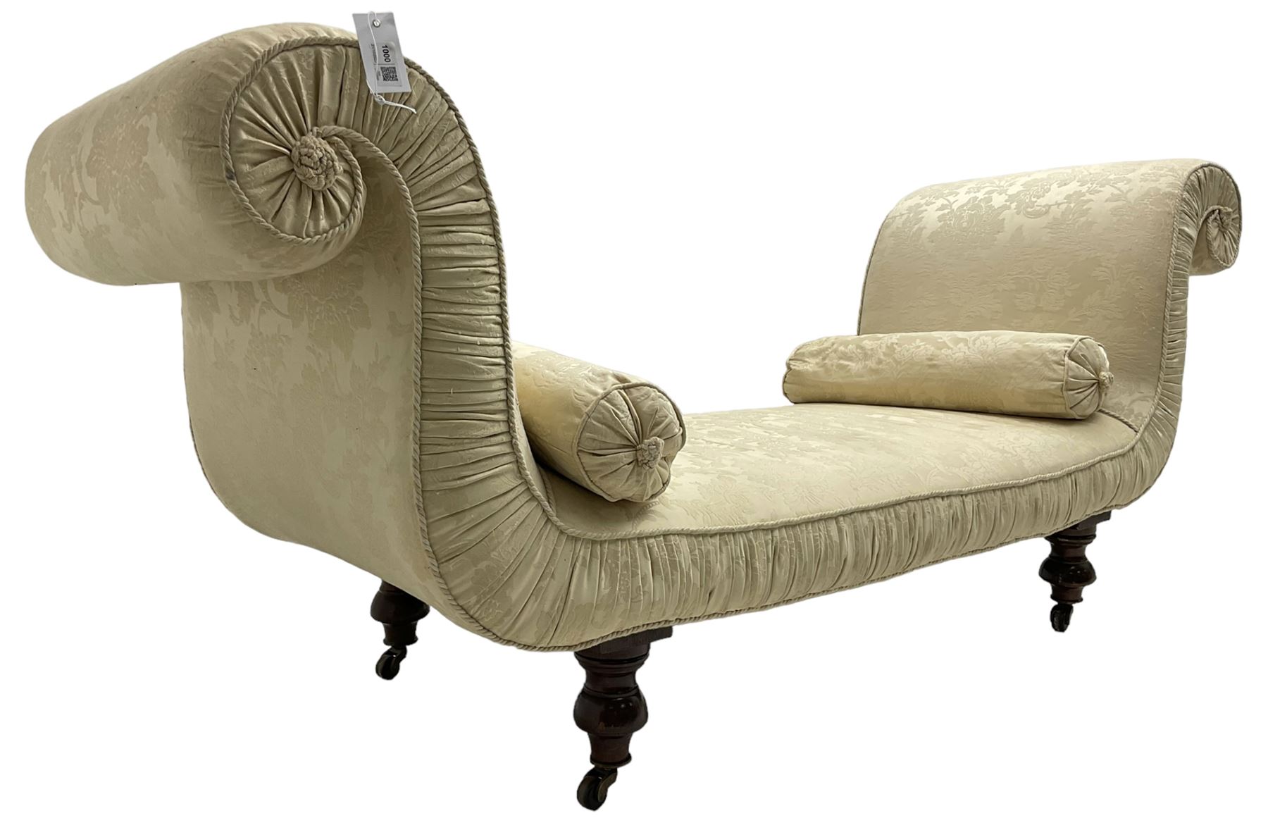 Victorian mahogany framed window seat day bed, the scrolled arms and seat upholstered in ivory foliate patterned damask fabric with matching ropetwist piping, raised on turned supports with castors