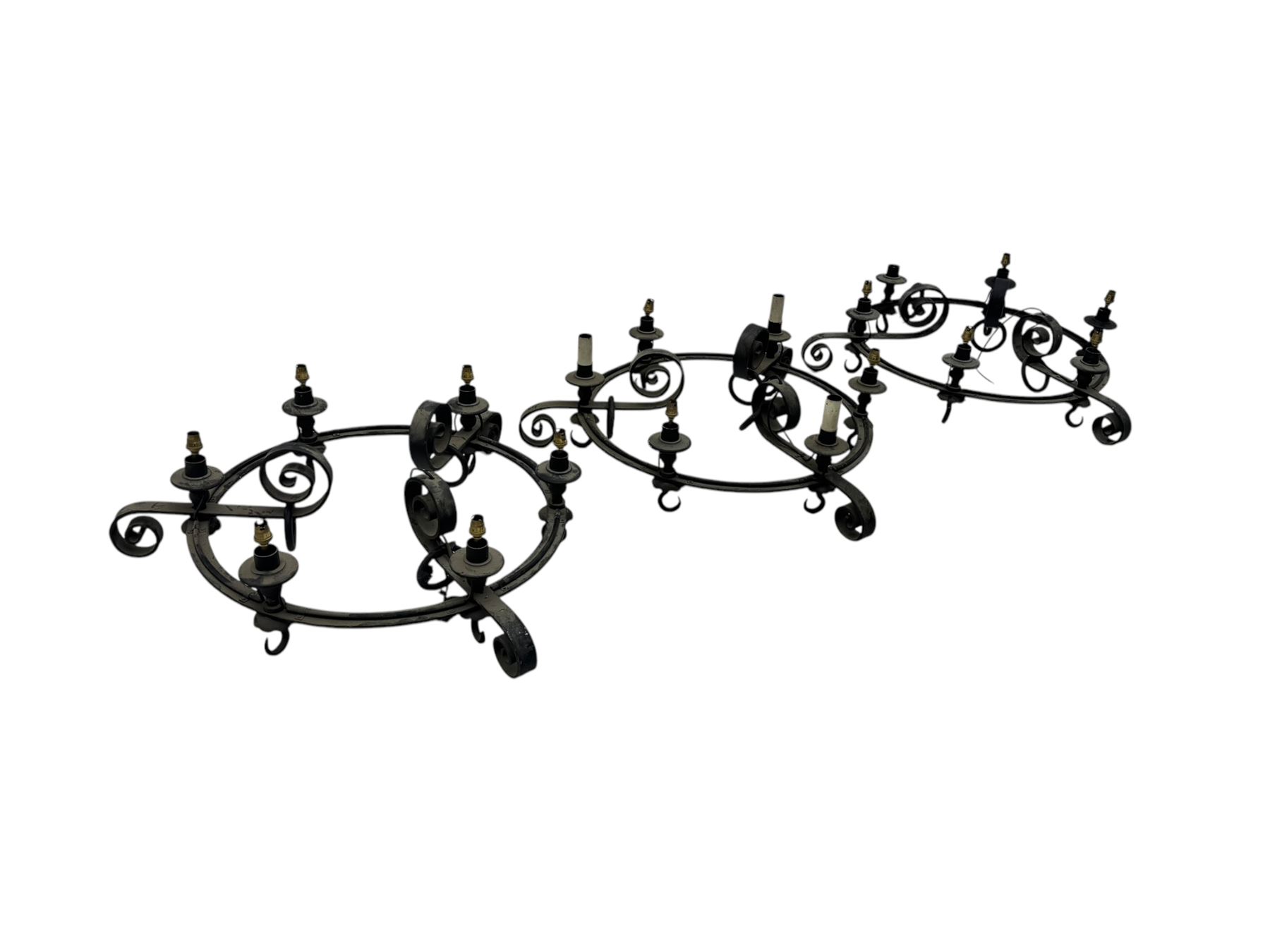 Set of three mid-20th century wrought iron six-light chandeliers, each with a circular frame with scrolled arms, faux candle sleeves and hook terminals