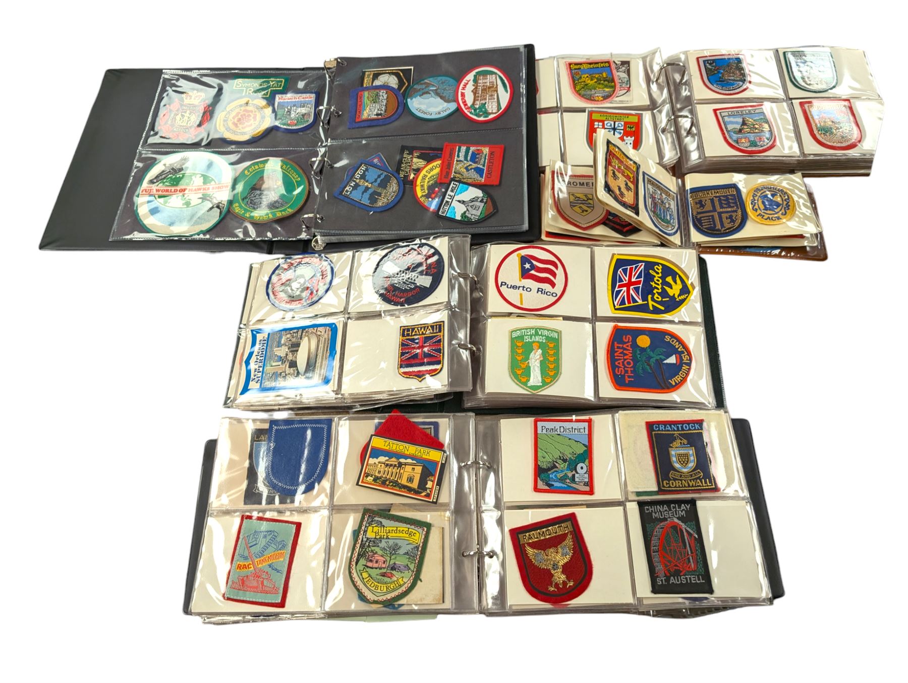Large collection of souvenir cloth badges and vinyl stickers, mostly contained within albums