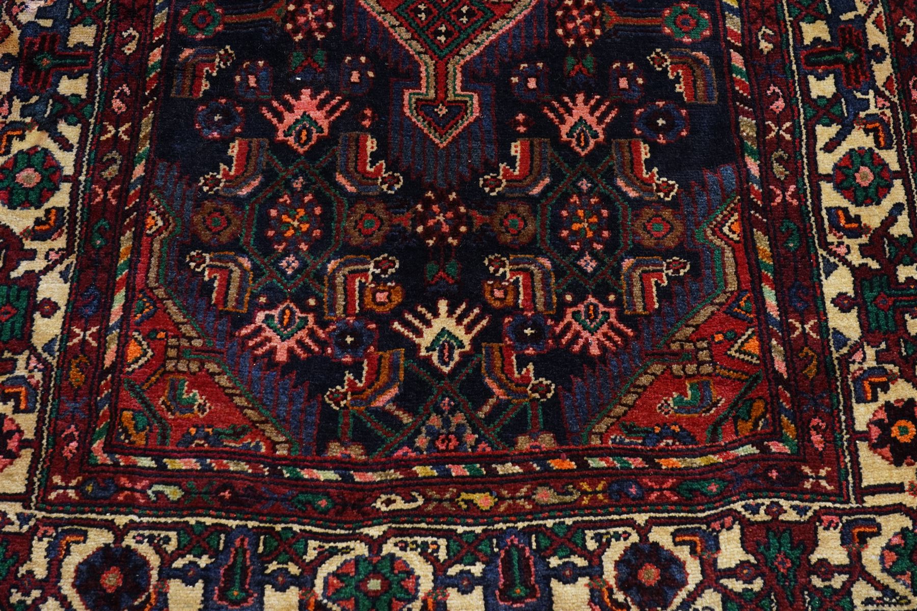 North West Persian Malayer hand-knotted runner, indigo field with vertical lozenge medallions surrounded by angular floral sprays, rosettes, and stylized palmettes, field enclosed by serrated ivory spandrels incorporating polychrome floral decoration, framed by ivory ground main border of stylized flowers and hooked devices, flanked by reciprocal guard stripes, cotton fringe ends 