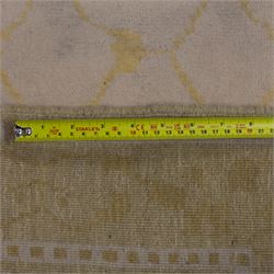 Tibetan wool rug, decorated with a pale cream ground and yellow all-over foliate design, enclosed by a broad yellow floral border and narrow inner guard band