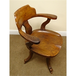  Edwardian walnut swivel office chair, curved shaped back and arms with saddle seat the four scrolled supports with ceramic castors   
