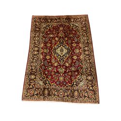 Persian Kashan deep red ground rug, all over floral design decorated with stylised flower heads, repeating guarded border
