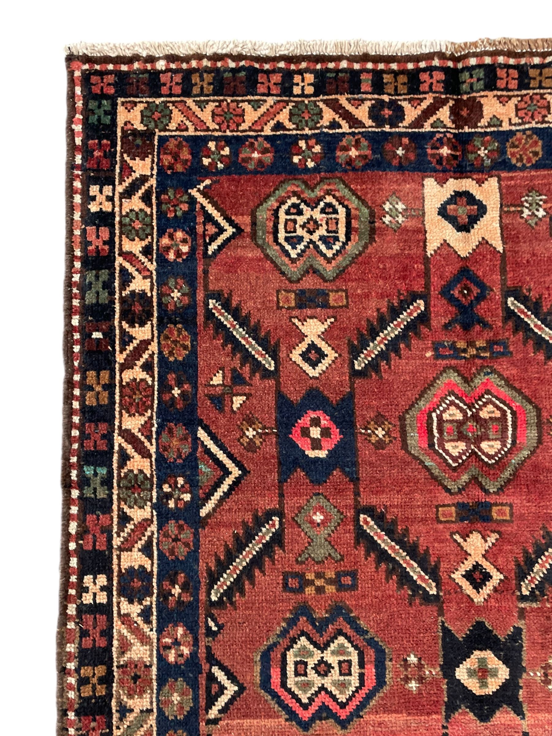 Near pair of Persian Azerbaijan red ground runners, each rug decorated with Nazarlik and stylised leaf motifs, enclosed with three band border decorated with flower heads and geometric motifs 

406cm x 99cm 
409cm x 102cm
