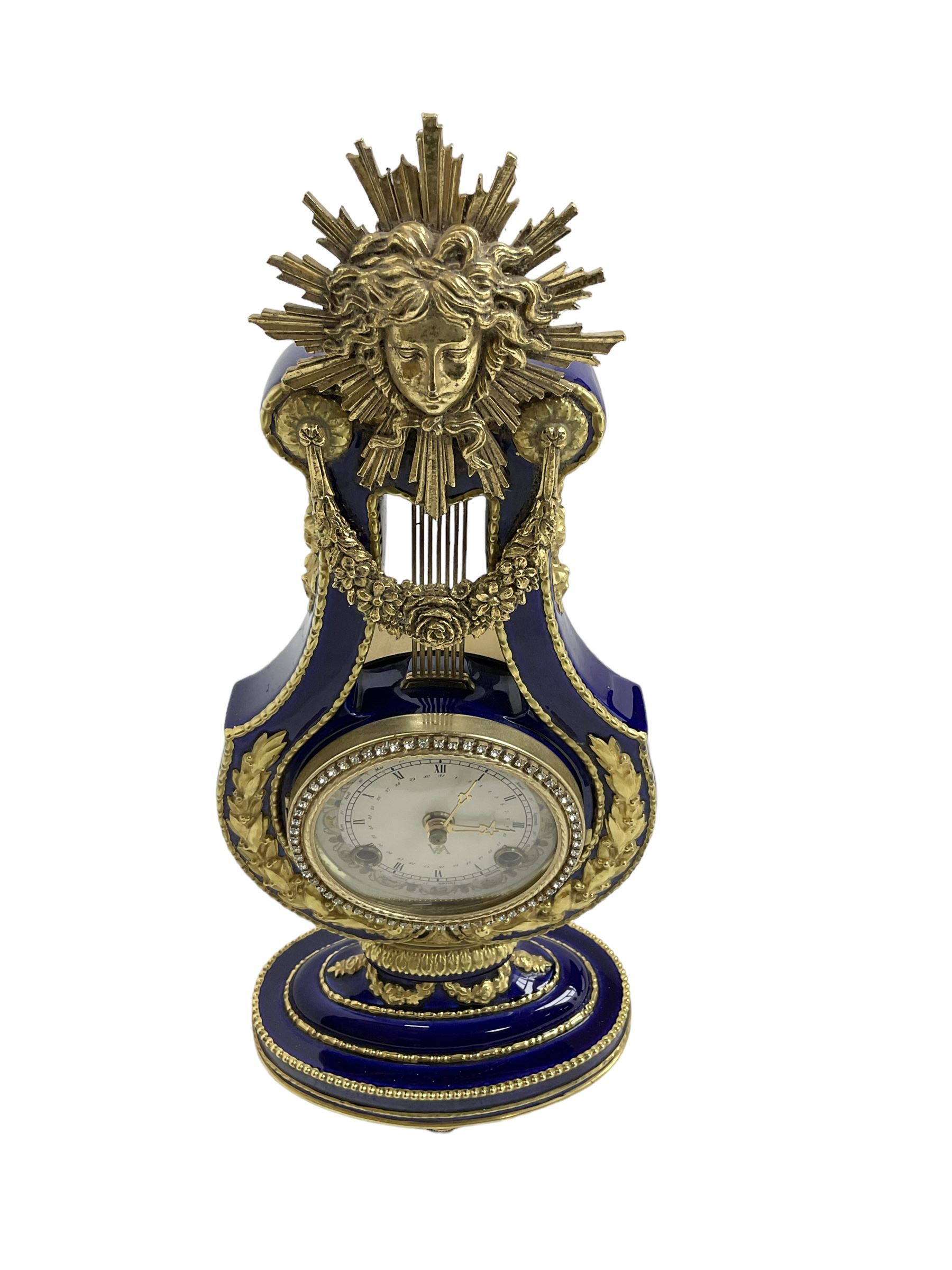20th century V&A Marie Antionette lyre clock - Blue porcelain with gilt mounts on a  oval stepped base, dial with roman numerals and gilt hands, continental twin train spring driven movement sounding the hours and half hours on two bells. With key.