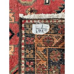 Near pair of Persian Azerbaijan red ground runners, each rug decorated with Nazarlik and stylised leaf motifs, enclosed with three band border decorated with flower heads and geometric motifs 

406cm x 99cm 
409cm x 102cm
