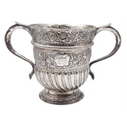 George I silver Britannia standard twin handled cup, the urn shaped bowl with twin scroll handles, later embossed part fluting, rope girdle and foliate decoration, and gilt interior, upon a circular stepped foot, hallmarked Matthew Lofthouse, London 1721, H16.5cm, approximate weight 19.75 ozt (614.2 grams)
