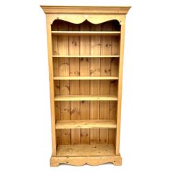Solid pine open bookcase, projecting cornice above five adjustable shelves, shaped plinth base 