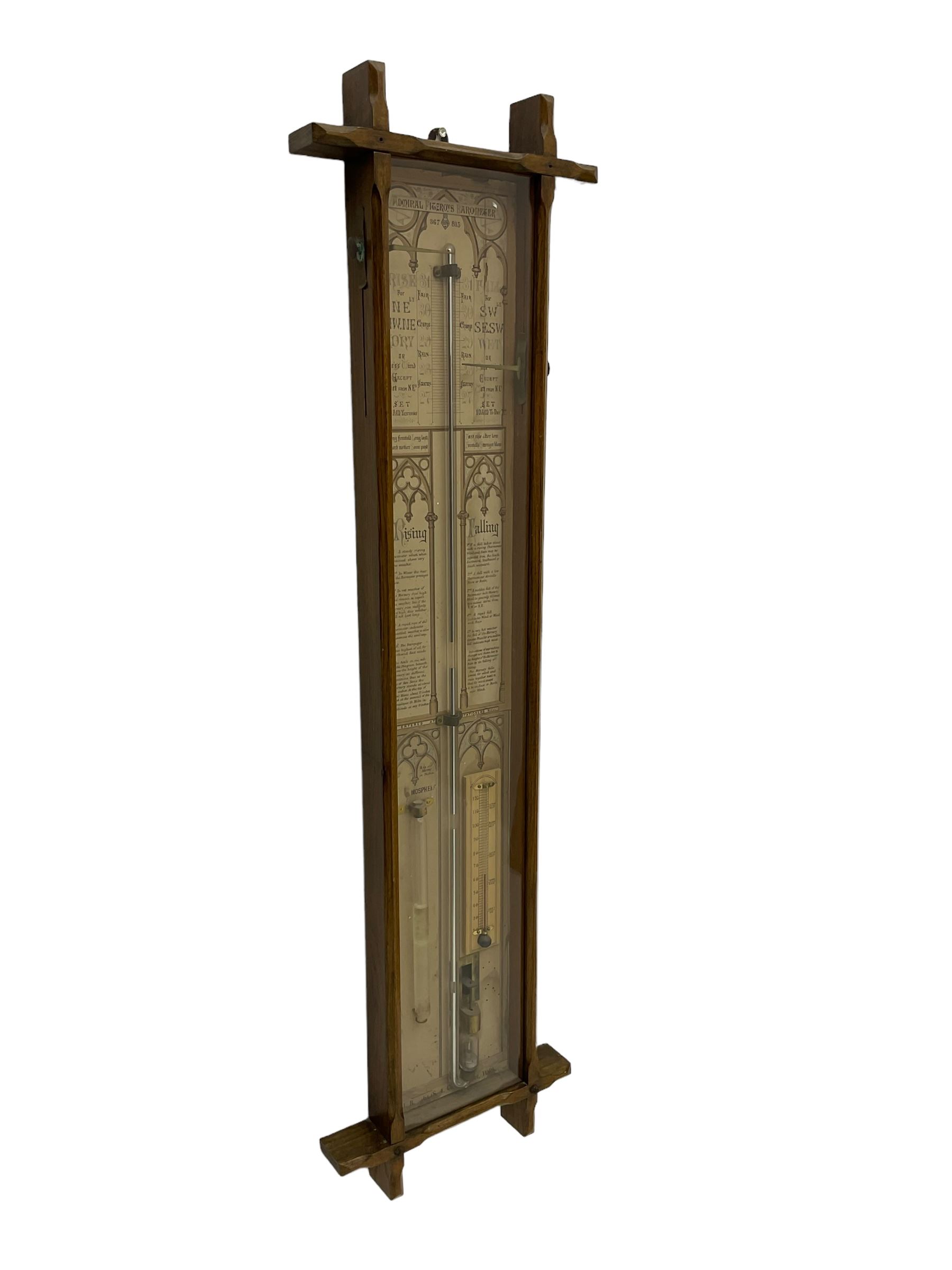 Admiral Fitzroy - Early 20th century Fitzroy barometer in a glazed gothic influenced oak case with chamfered uprights and top and base panels, full length paper scales with Fitzroy's observations and predictions, mercury bulb cistern, storm glass, spirit thermometer and brass sliding vernier pointers. Retailed by Inglis & Son, Coney Street, York.