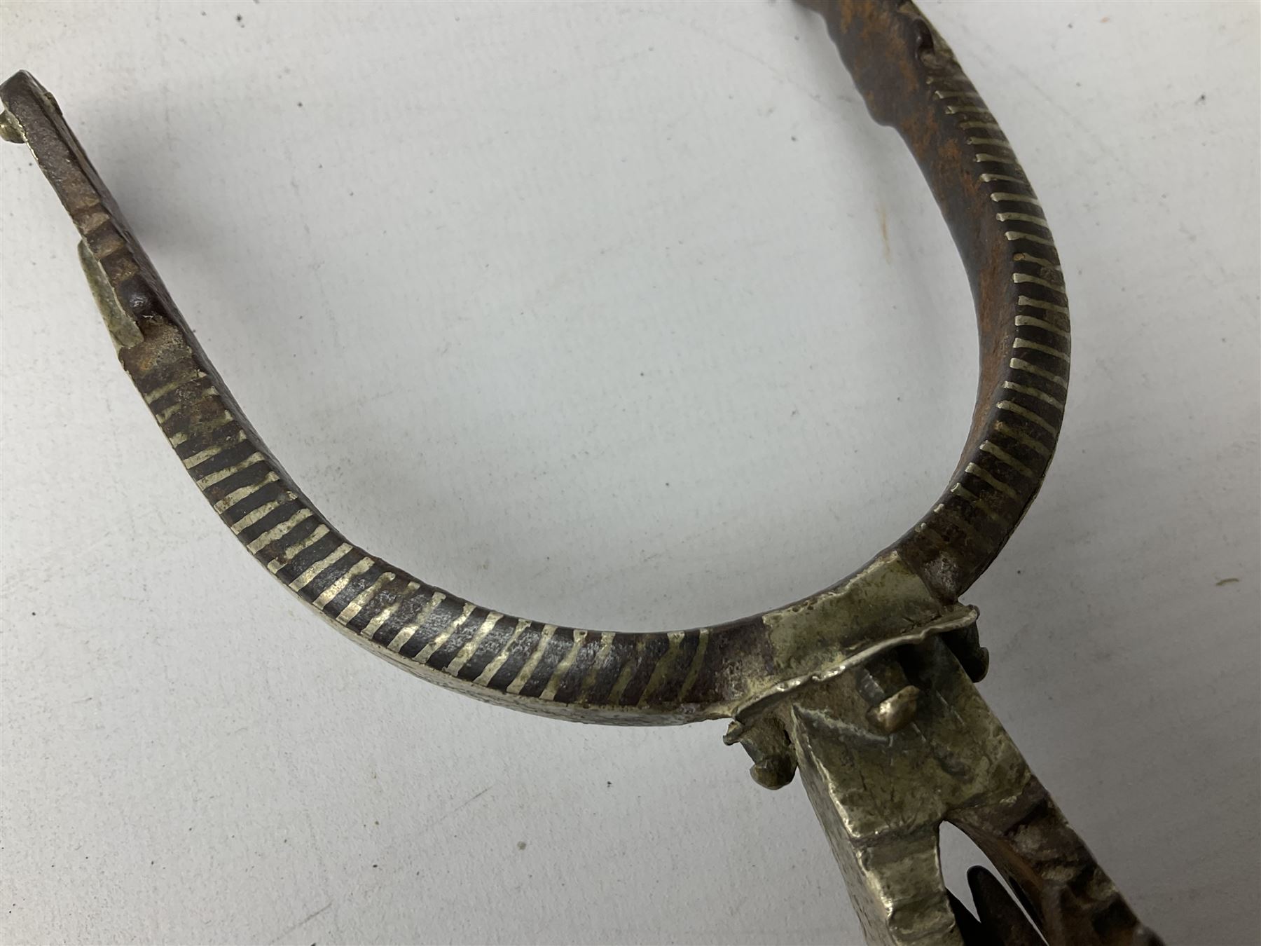 Pair of late 19th century South American iron spurs, engraved silver mounts, with sunburst rowls