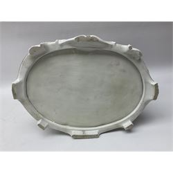 20th century Naples figure group, modelled as a seated female figure playing the lute seated, before a male figure stood holding a sheet of music, each in period dress, upon an oval base with gilt heightened scroll edge, with crowned N mark beneath, H31.5cm L33cm
