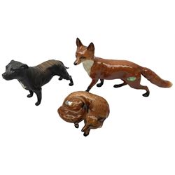 Three Beswick figures modelled as a fox in recumbent pose no.1017, standing fox no.1016a and matte brindle Staffordshire Terrier no.3060, all with printed mark beneath 