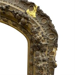 19th century giltwood and gesso moulded picture or mirror frame, the arched cresting rail mounted by central cartouche decorated with foliate scrolls and fruit, the outer frame decorated with scalloped edge and shell mouldings, trailing foliage with flower head and fruit to the central band, egg and dart moulded inner slip