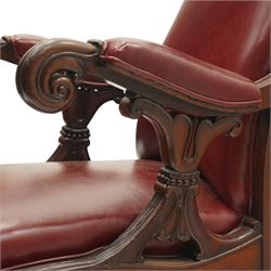 William IV mahogany high-back library reading armchair, arched cresting rail with moulded C-scrolls and bellflowers, the padded arms raised on waisted supports with lappet style carving below scrolled arm terminals, the lower reeded frame raised on splayed supports with brass cups and castors, upholstered in red leather with sprung seat