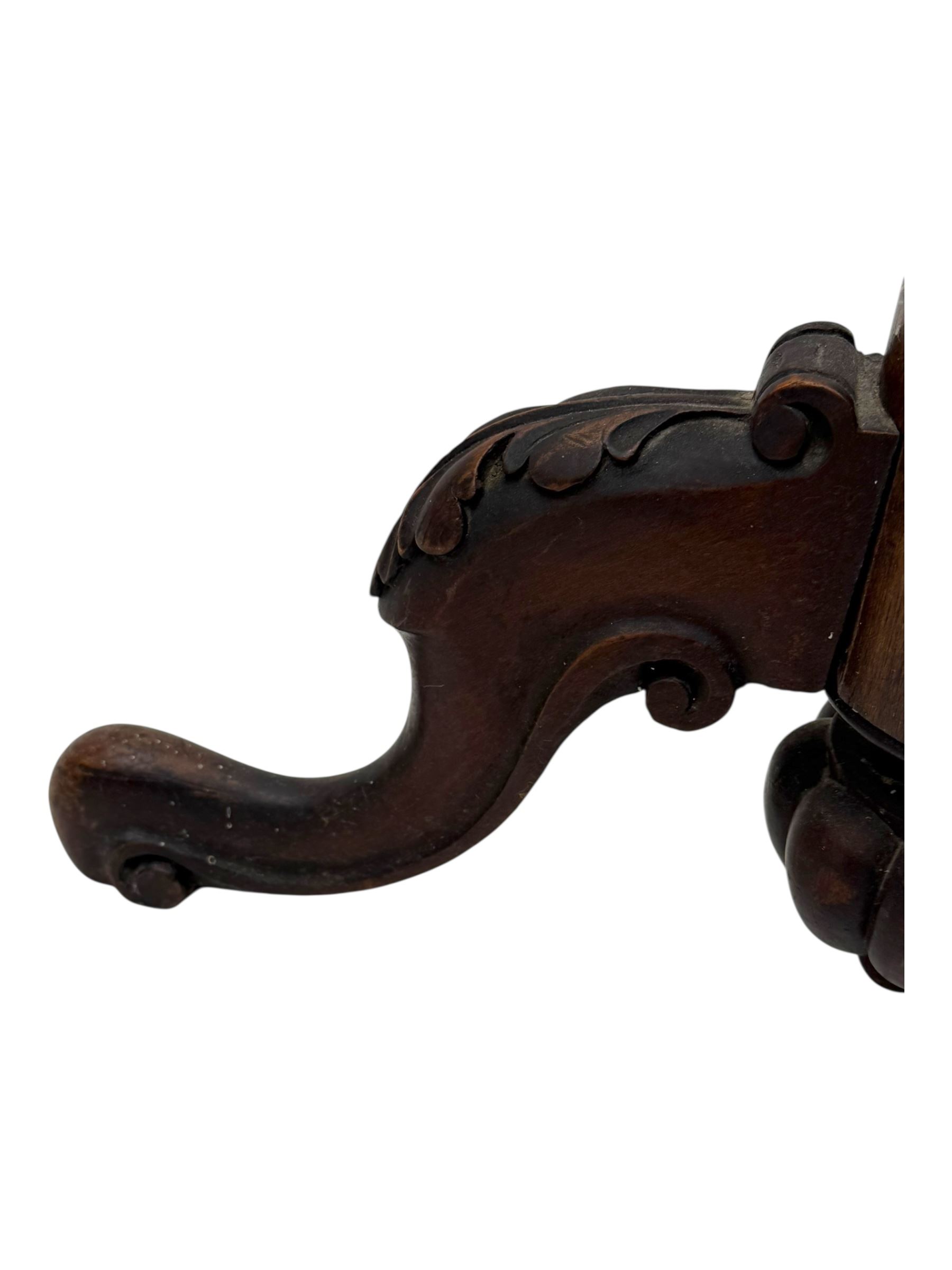 Late 19th century mahogany torchère stand, with circular top above a twisted and foliate carved collumn, on a scroll carved tripod base, on cabriole legs