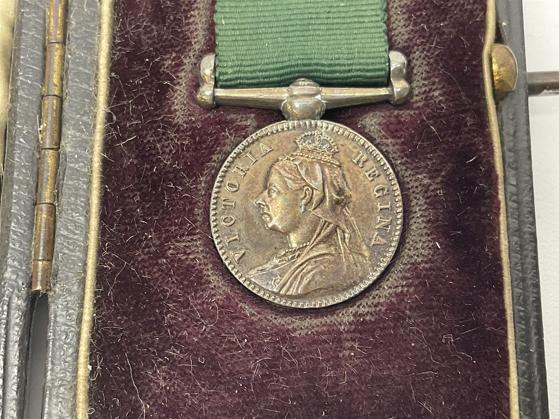 Victoria Volunteer Officers’ Decoration, V.R. cypher, hallmarked silver London 1892, with integral top riband bar and ribbon, unnamed; the matching miniature; and Victoria 'For Long Service in the Volunteer Force' miniature medal with ribbon in original case (3)