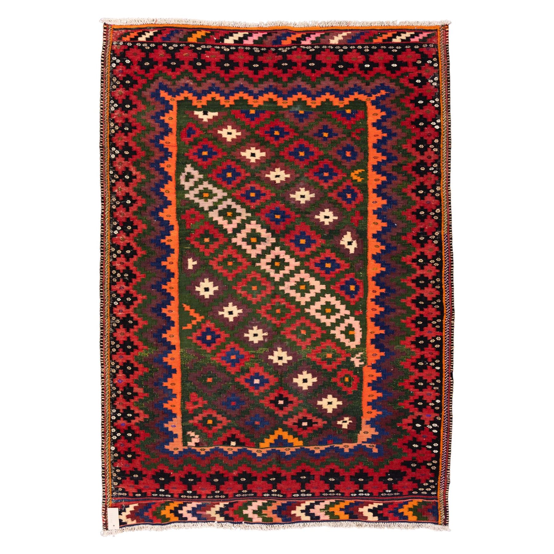 North East Persian Sumak flatweave kilim, woven with an all-over arrangement of stepped diamond motifs, including a diagonal band of contrasting colours in shades of red, indigo, green, pink, and ivory, framed by multiple geometric borders incorporating serrated chevron designs  