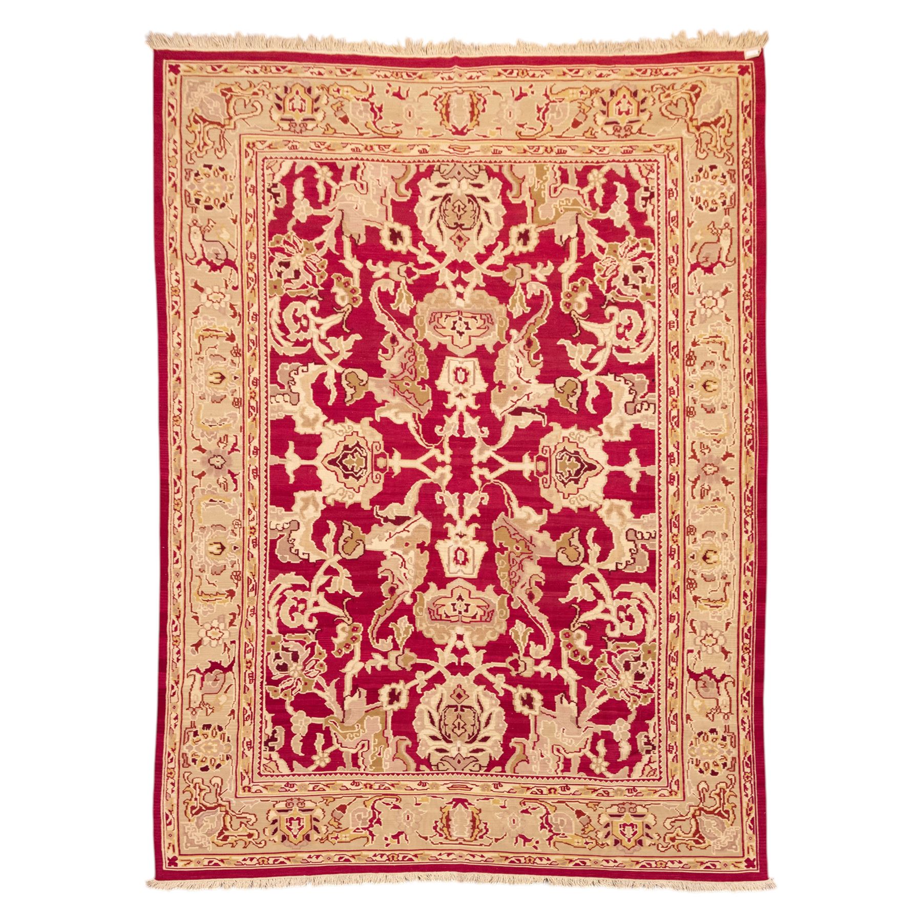 Large Persian Savonnerie-inspired style flatweave kilim, crimson field with central stylized palmette medallion with bold scrolling vinery and angular floral motifs between multiple guard stripes, rendered in tones of soft cream, pale sage, and muted terracotta, with fringe ends 