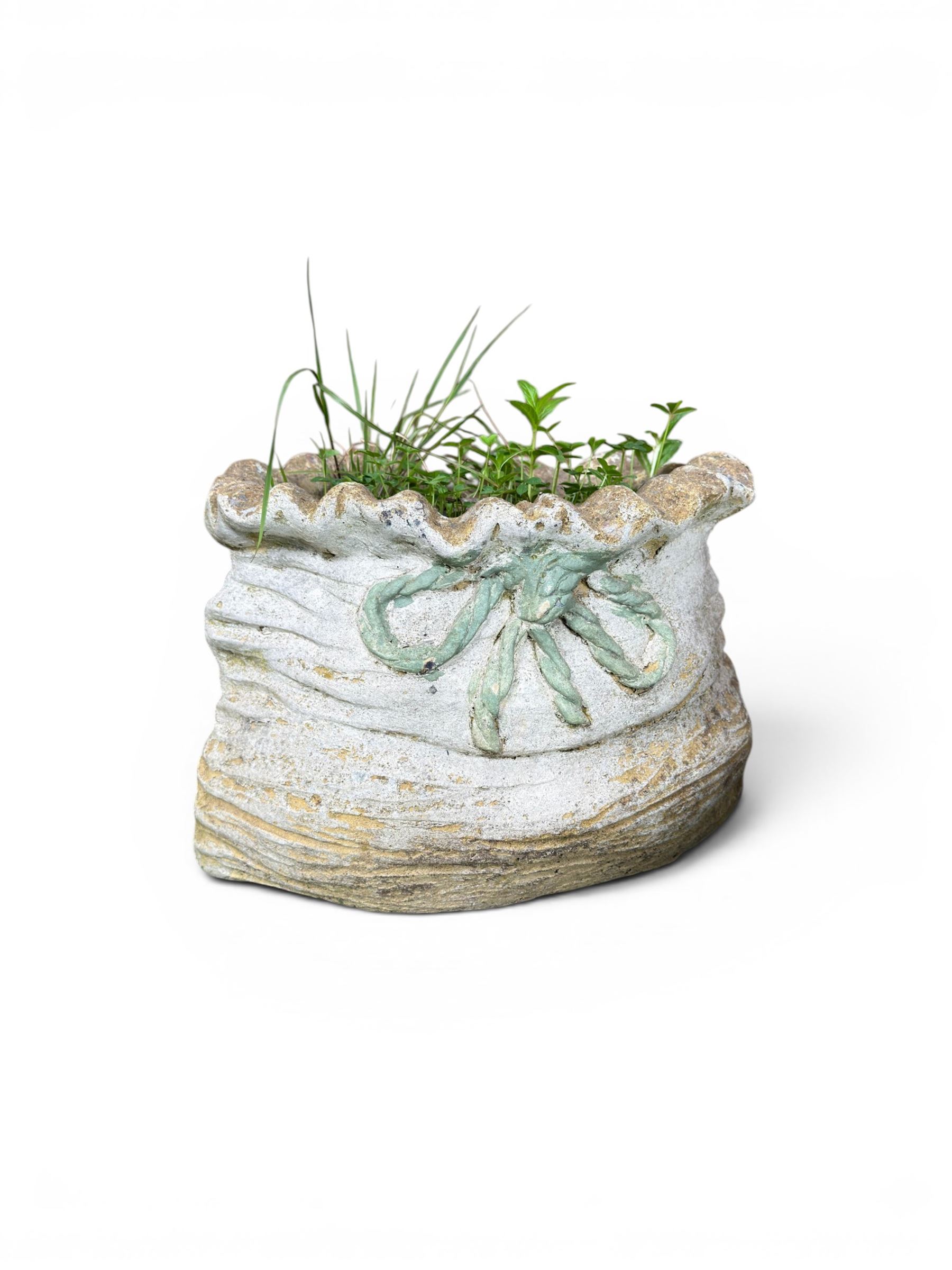 Four cast stone garden planters in the form of ribbon tied planting sacks
