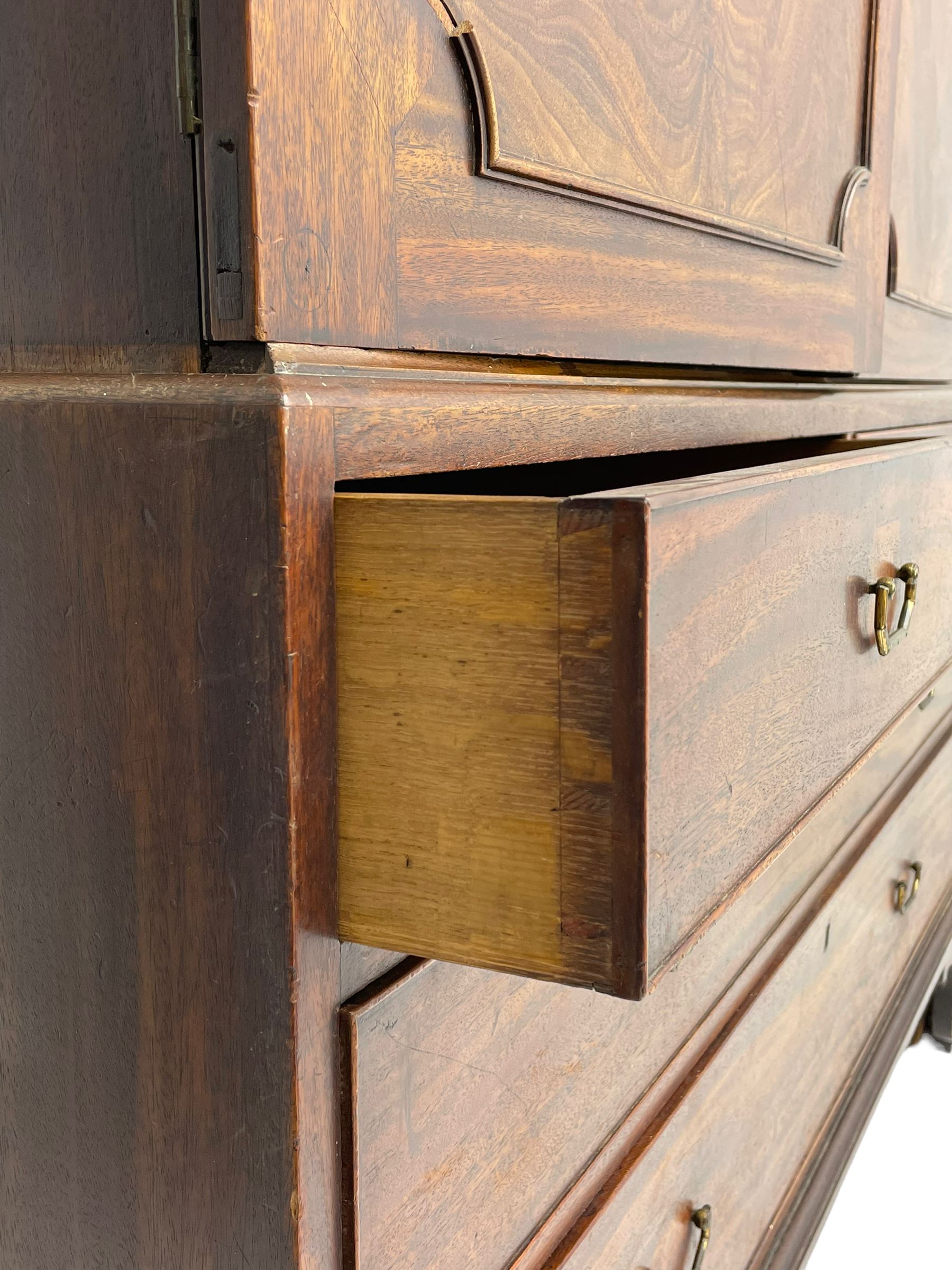 George III mahogany linen press, projecting cornice over two figured doors enclosing five linen slides, the lower section fitted with two short and two long drawers, on bracket feet