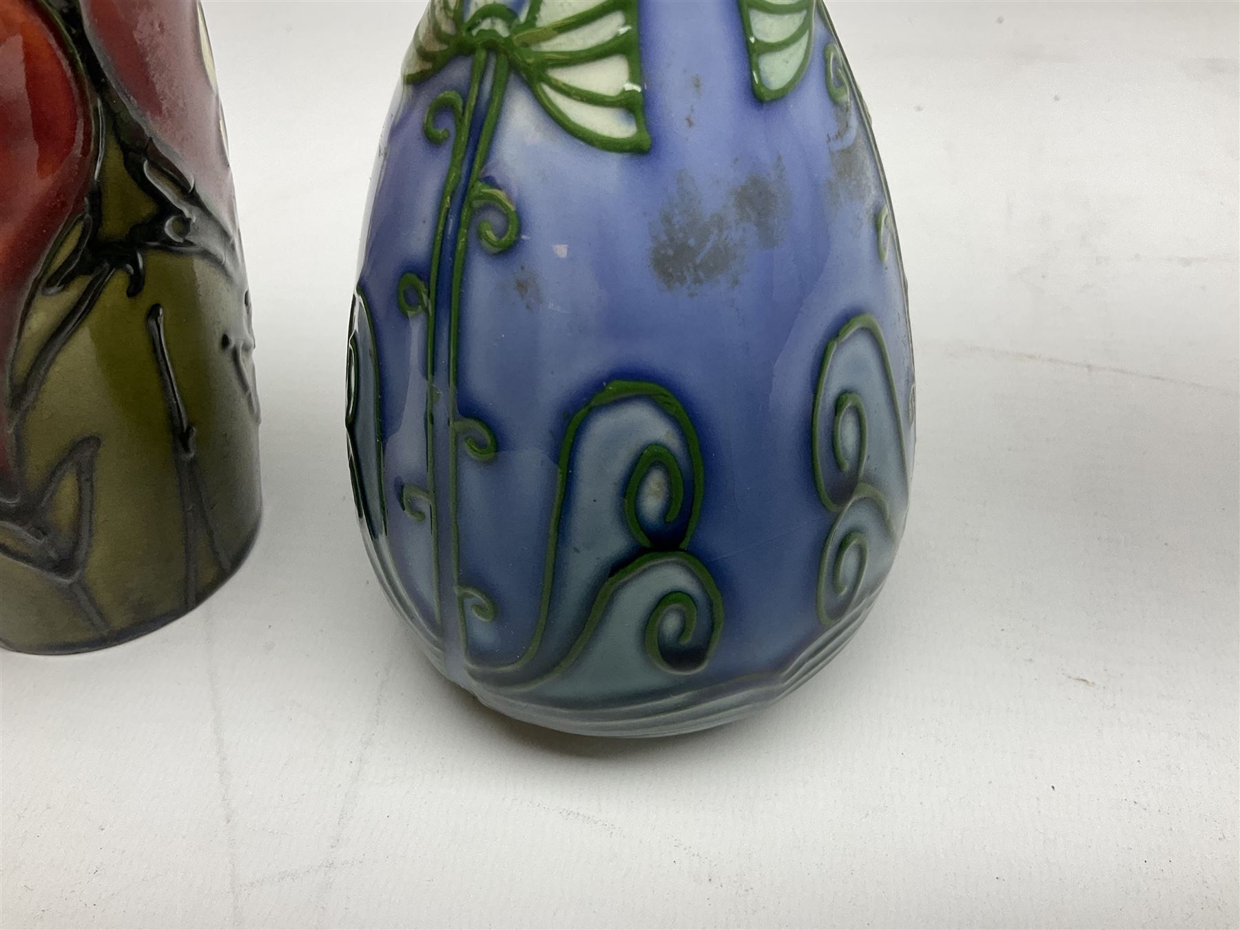Minton Secessionist vase, with tube-lined stylised flower head decoration on a blue ground, printed mark to base 'Minton Ltd, No. 30', together with another Minton Secessionist tubelined vase,  printed mark to base 'Minton Ltd, No. 16', tallest example H13.5cm