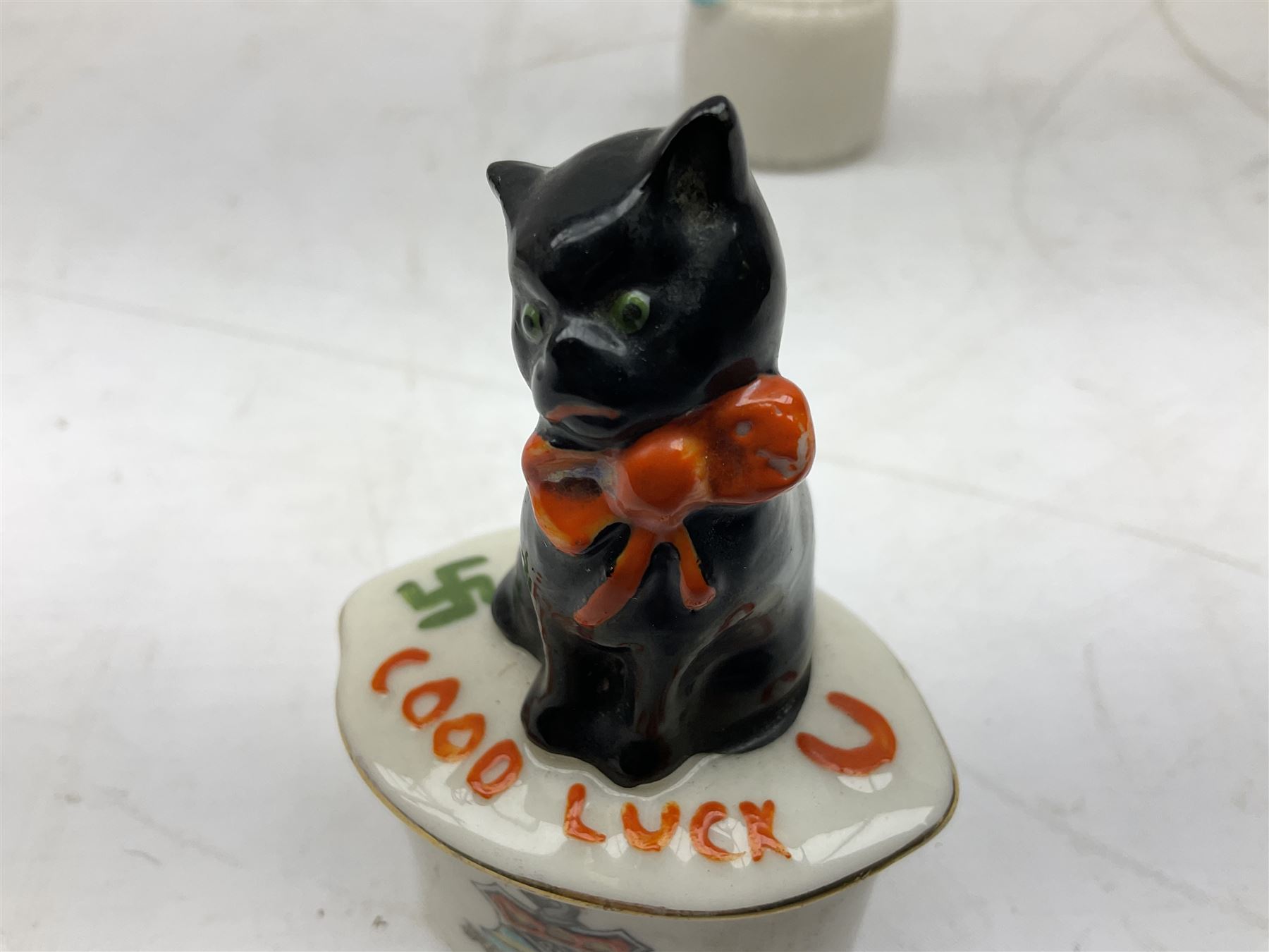 Five crested ware Good Luck black cats, comprising two Willow Art examples, two Arcadian examples and one Carlton China, to include Bridlington, Hull, Filey, etc, tallest H9cm