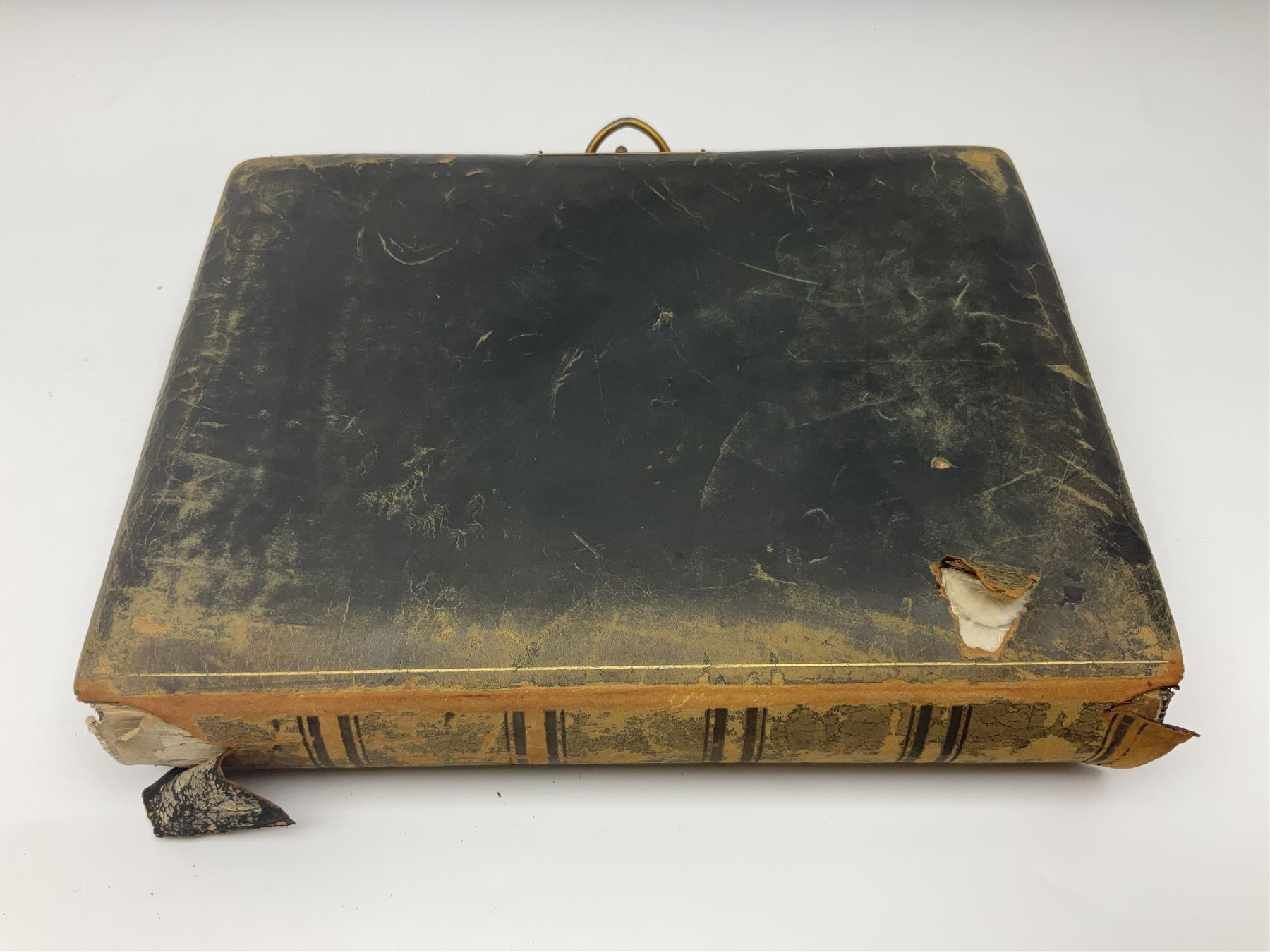  Victorian leather bound photo album, the interior leaves containing apertures of various sizes and shapes of portraits surrounded by printed floral designs, with brass clasp and painted gold decoration to edges, H30cm