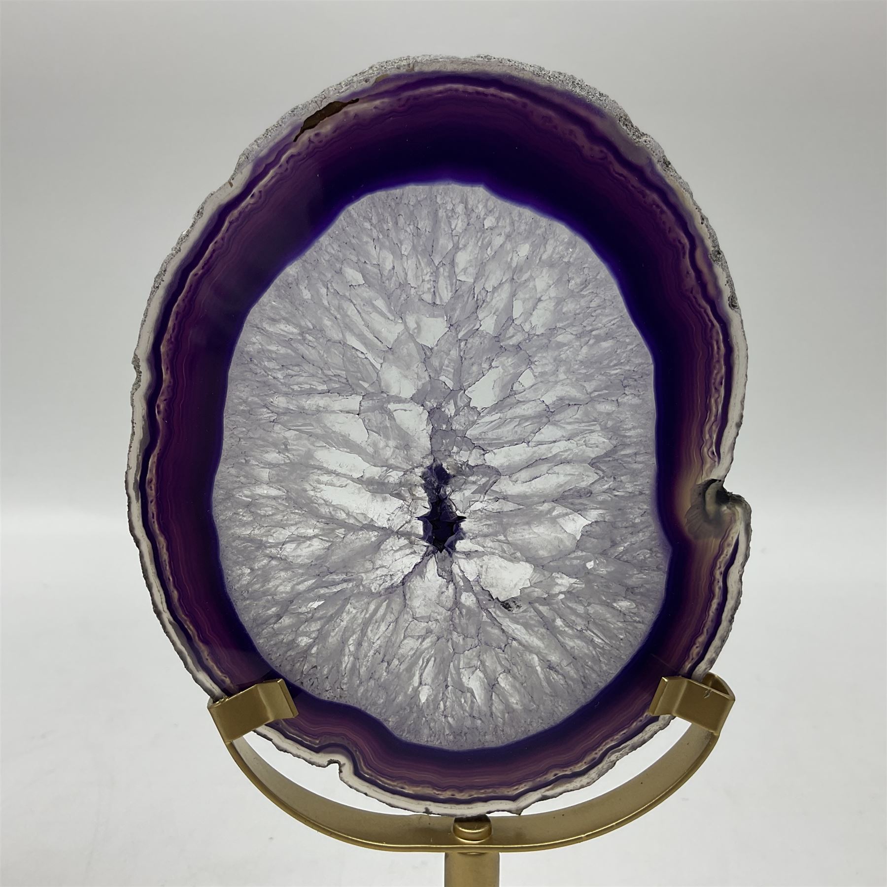Pair of purple agate slices, polished with rough edges raised upon gilt metal stands