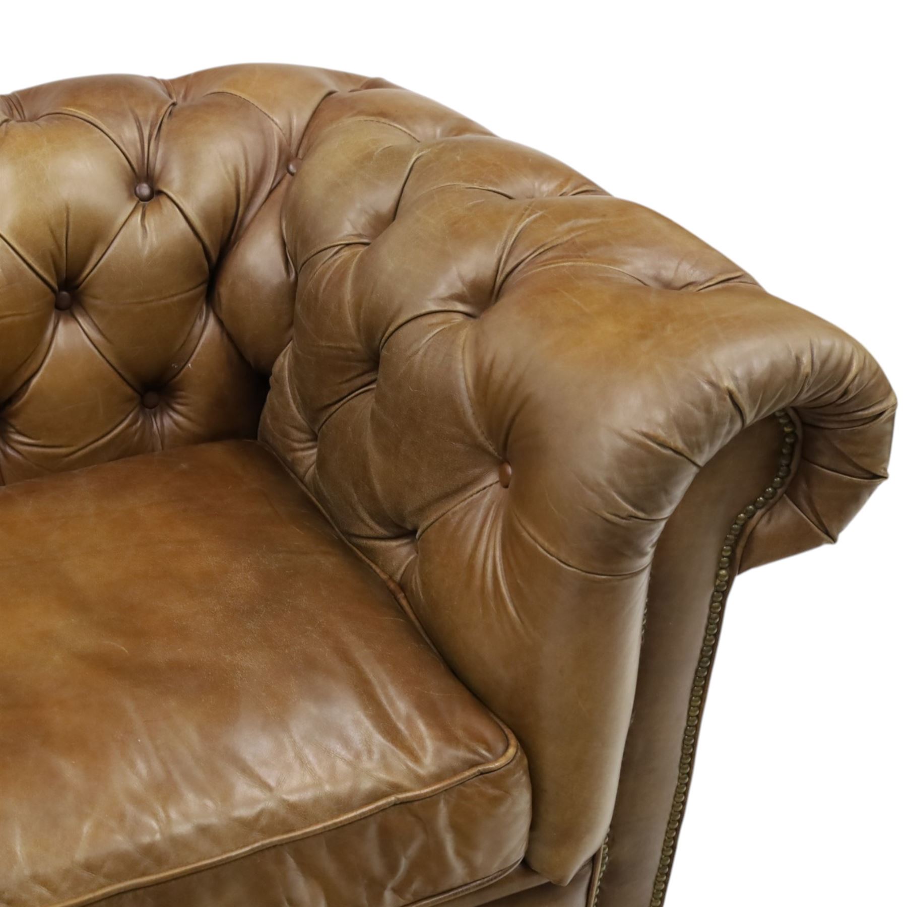 Timothy Oulton for HALO - Two seater brown leather chesterfield sofa, with button back and arms, with two loose cushions, raised on a dark stained supports terminating in castors 