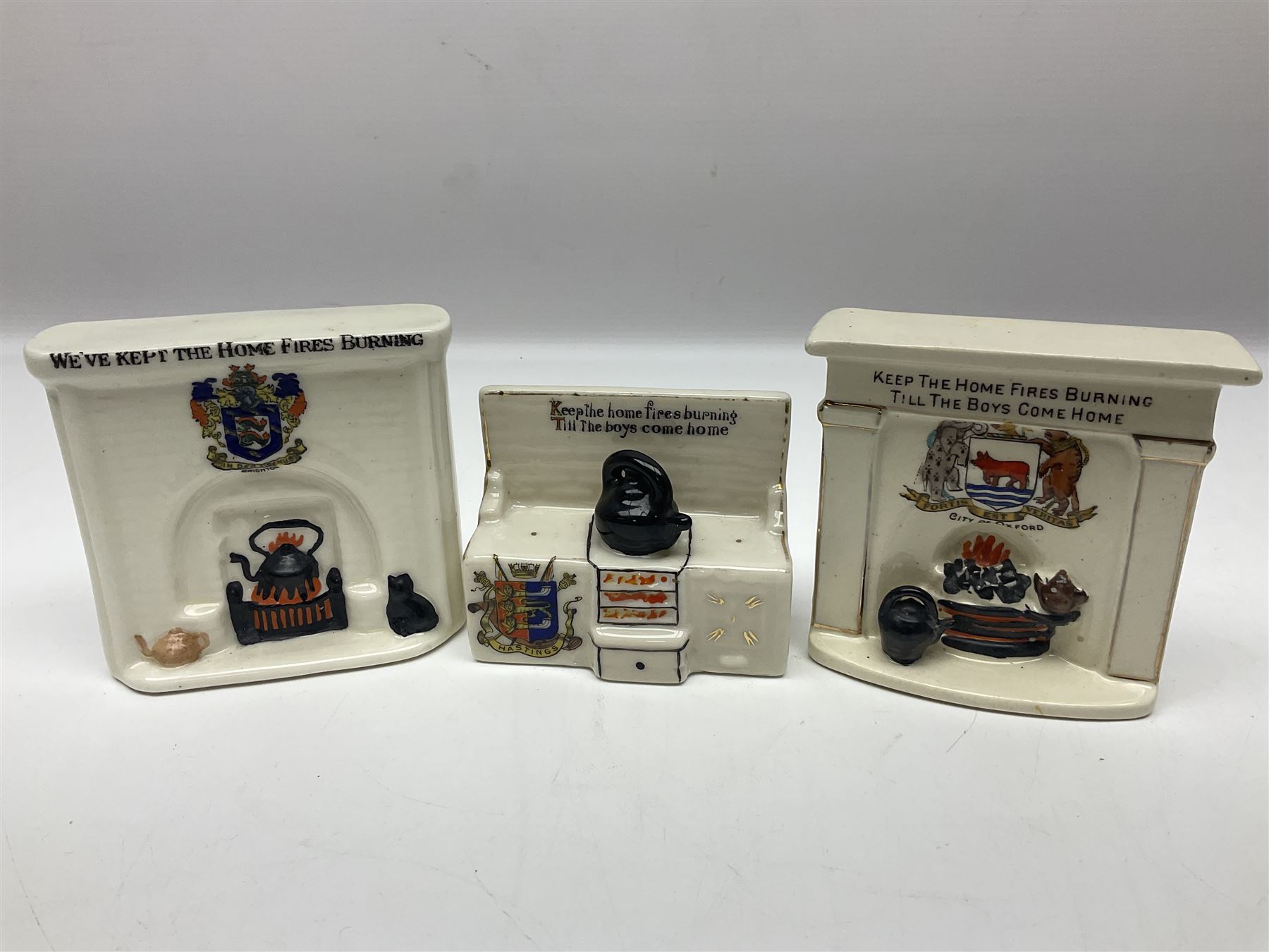 Ten WW1 crested china military models comprising seven field ambulances and three 'Home Fires Burning' fire-surrounds/range; various makers including Willow Art, Arcadian China, Grafton China, Savoy China, Carlton China etc; various crests including Devon, Aldershot, Portsmouth, West Ham, Coventry, Oxford, Hastings, Brighton etc (10)