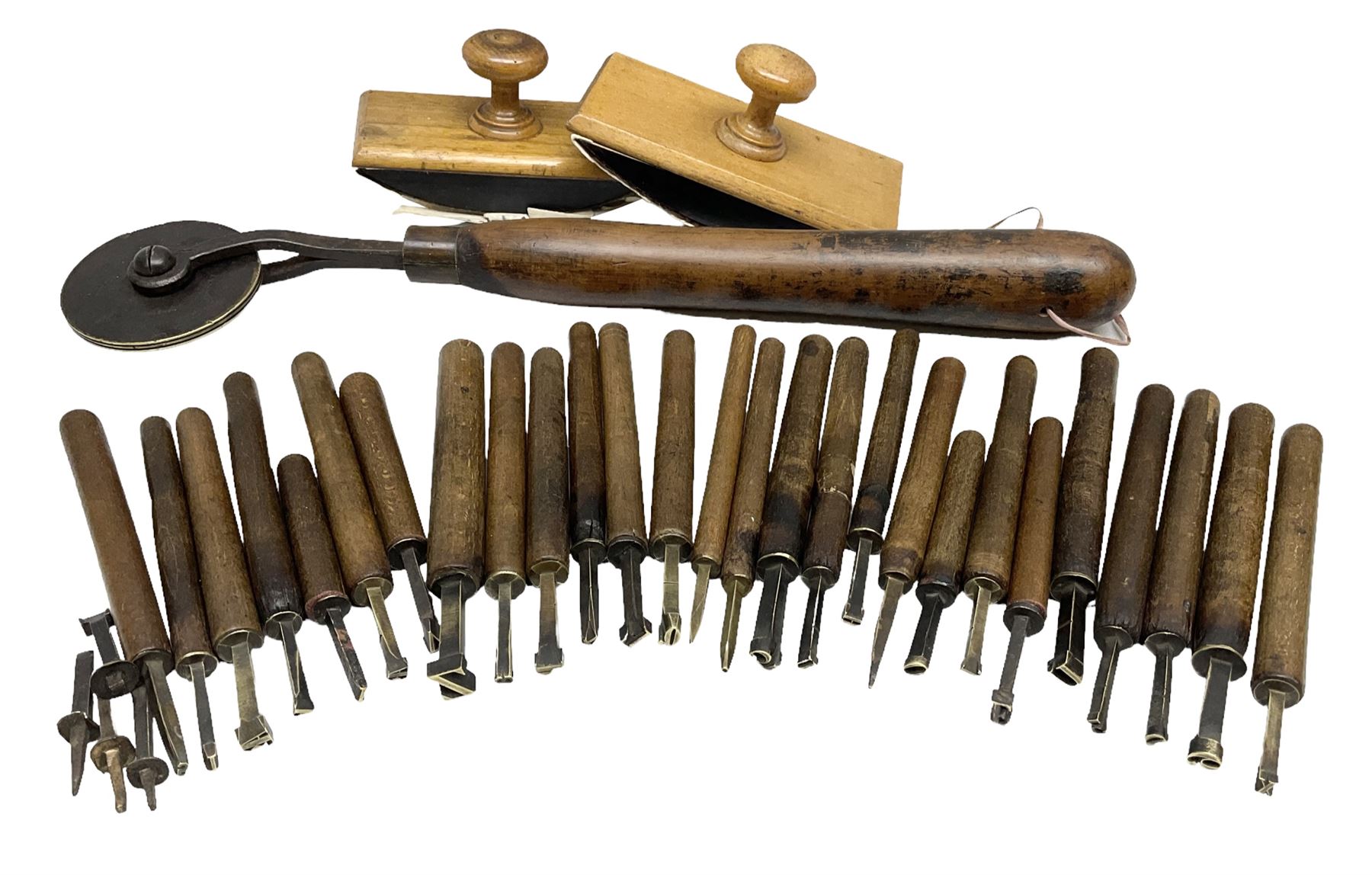 Thirty-one bookbinder's brass number and letter stamps, predominantly with beech handles, together with a bookbinder' decorative fillet roll, with brass triple line wheel stamped E. Menuel London, with wood handle, and two ink blotters