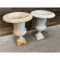 Pair of large Victorian design white painted cast iron campana shaped garden urns, egg and dart rim over a gadrooned underlobe, tapering column on square plinth base